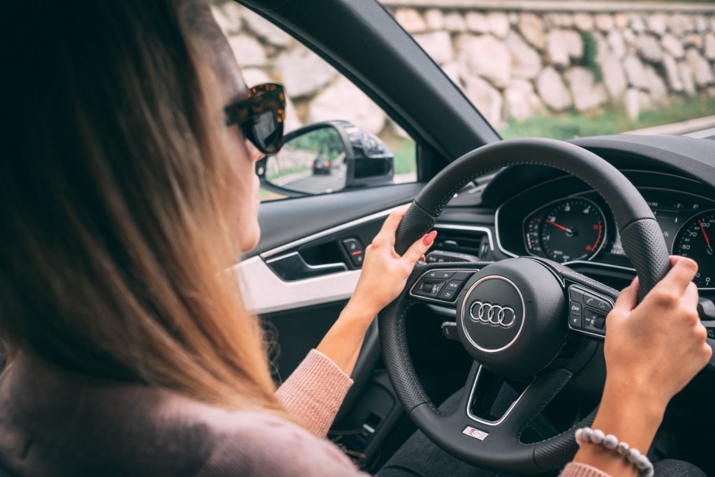 woman driving car in sunglasses