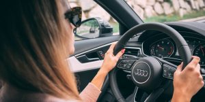 woman driving car in sunglasses