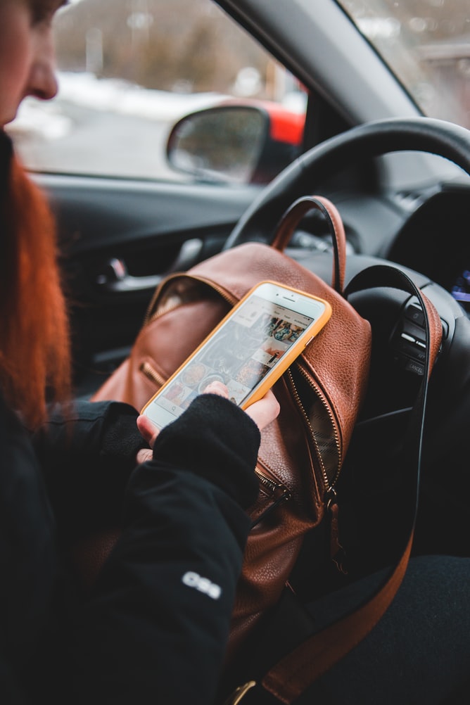 woman on her phone in car